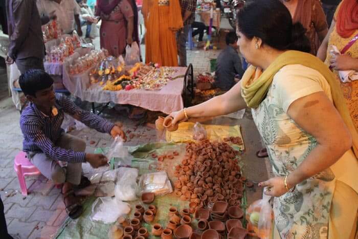 A woman buys clay lamps, named diyas used for the decoration and Puja (prayers), in a market in New Delhi.