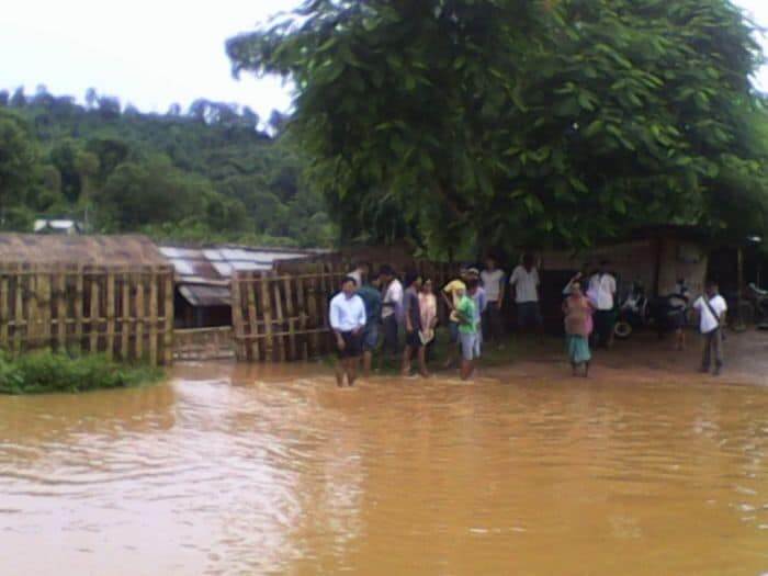 villagers stand in flooded area