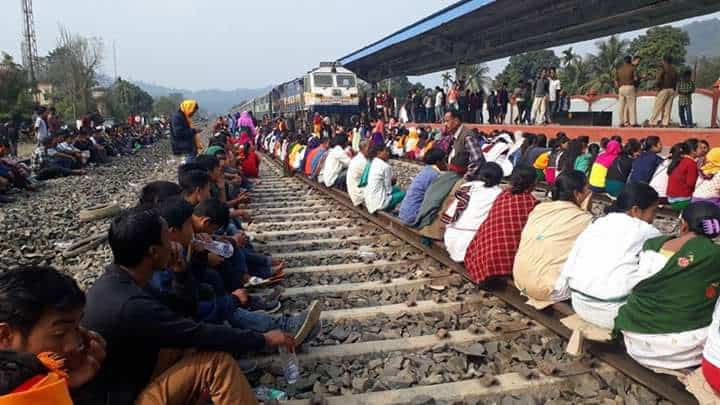 people sit on train line in protest.